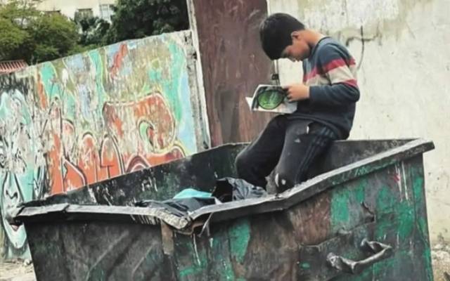 Hussain Reading Book on Garbage Box