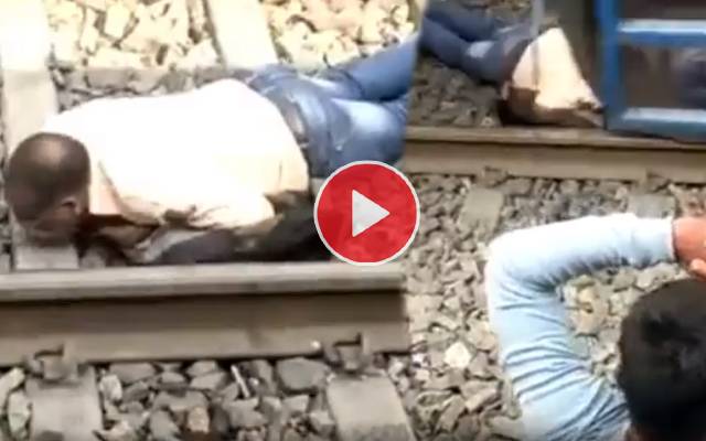 man tries to get out from under a goods train to change the railway platform,